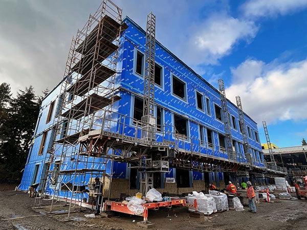 a 3-story building under construction with brick being put on the bottom level