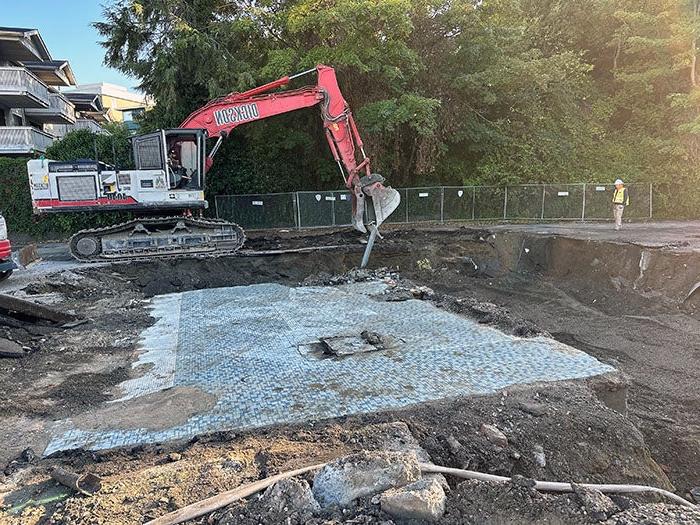 a back hoe demolishing a building floor